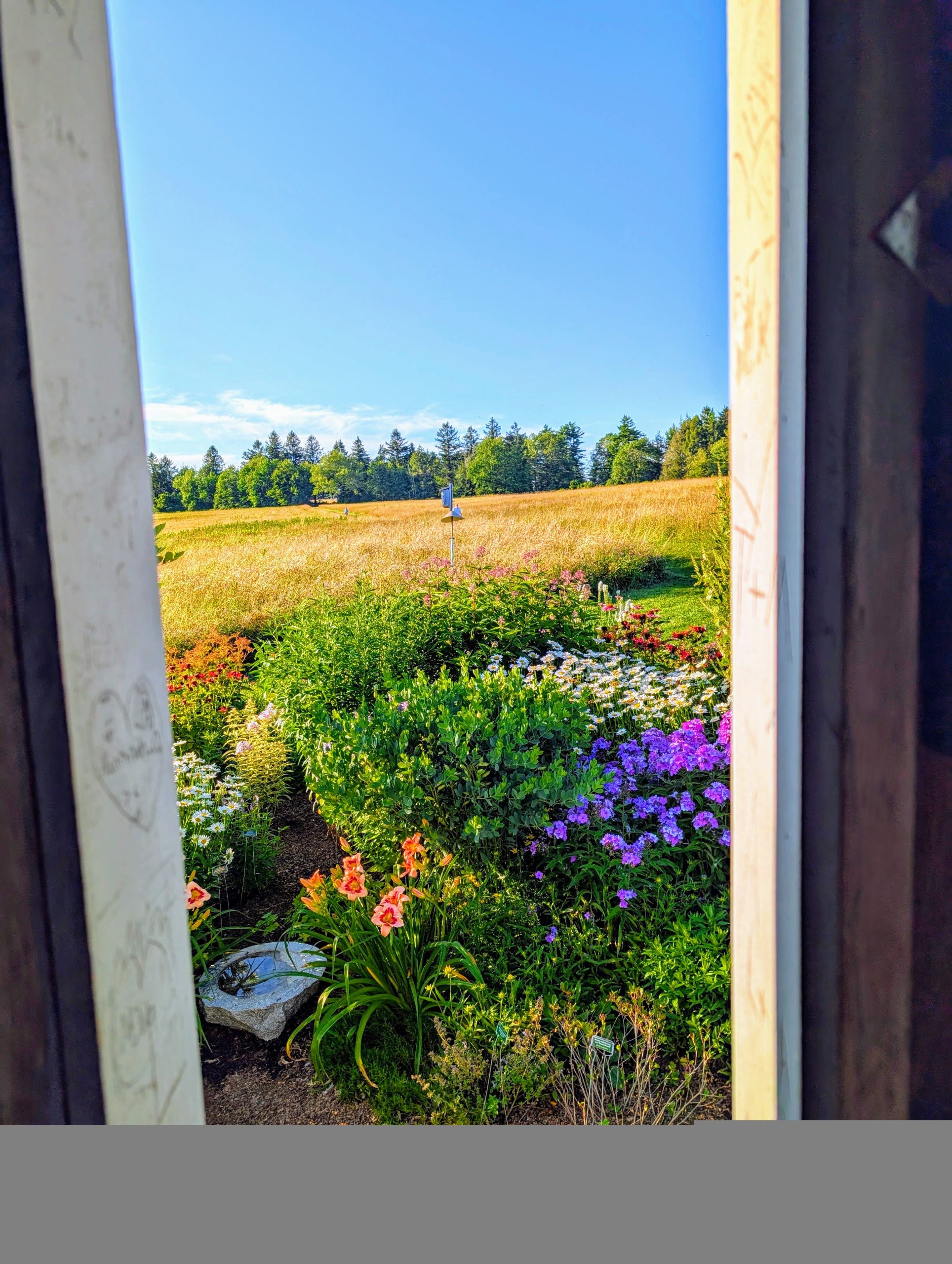 A window view of the garden and fields.