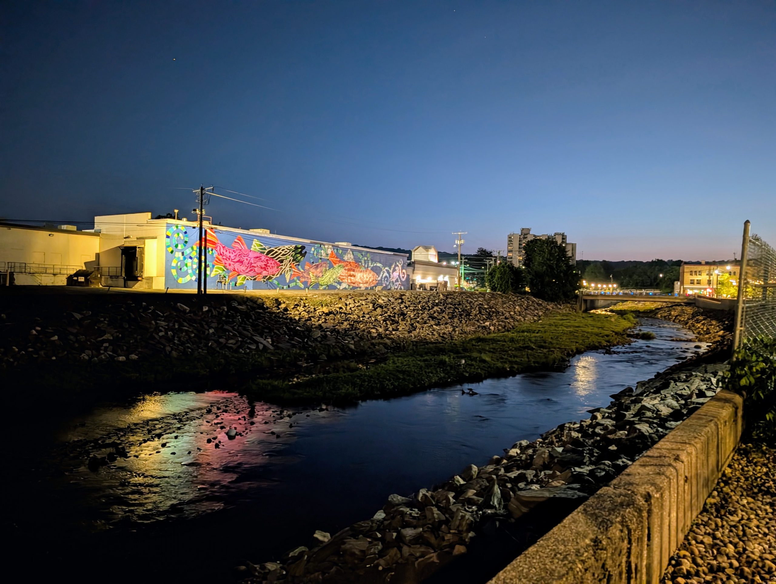 In town nighttime view of the Naugatuck River and one of the many murals in Torrington.